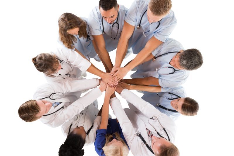 medical team holding hands together